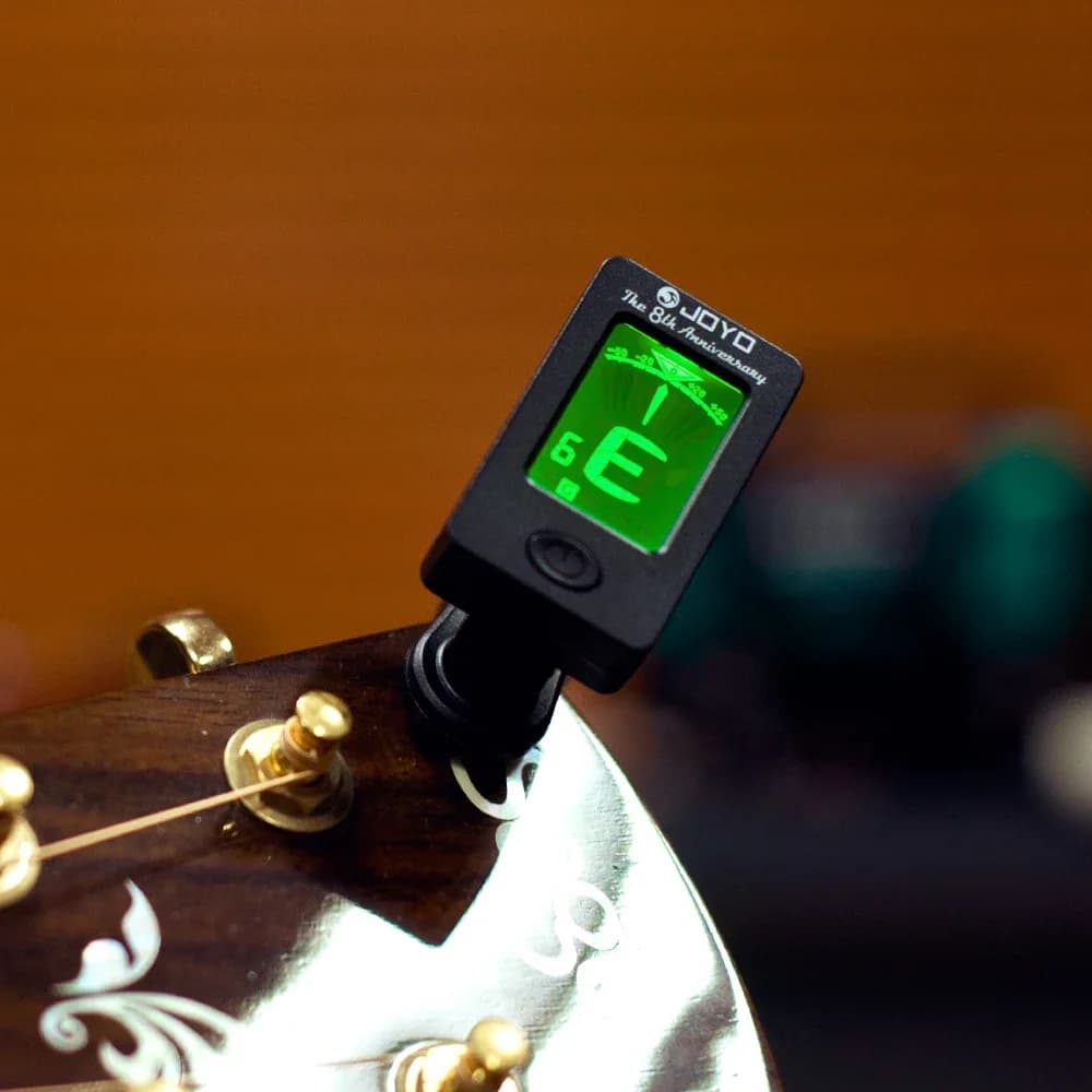 Accordeur chromatique à pince monté sur une tête de guitare, écran orienté vers le joueur