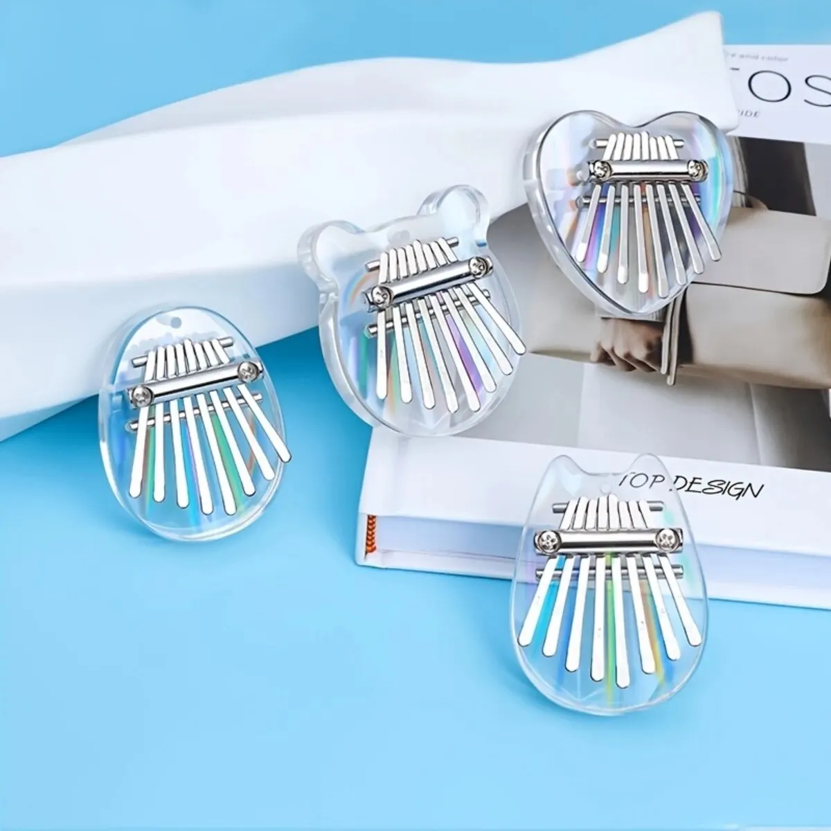 Kalimba 8 lames en bois découpé en forme de cœur posé sur une revue ouverte