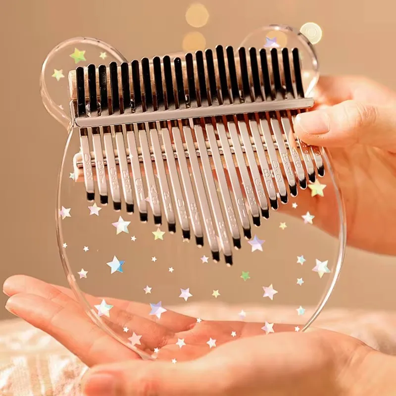 Kalimba acrylique 21 lames à effet cristal étoilé tenu dans une main