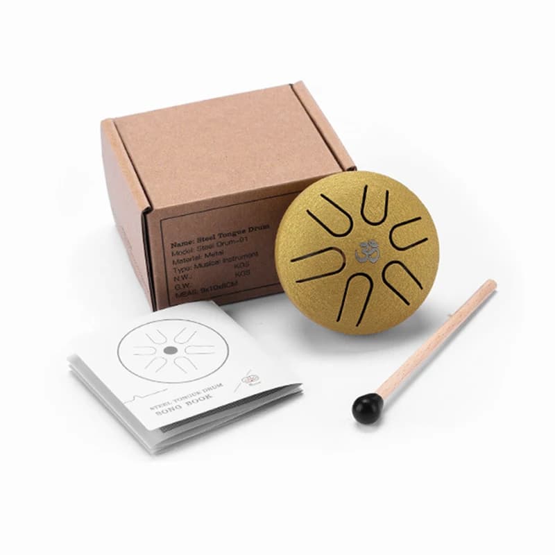 Mini tongue drum doré de 8 cm présenté avec sa boîte et sa mailloche